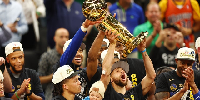 Stephen Curry raises the Larry O'Brien Championship Trophy after the Golden State Warriors defeated the Boston Celtics, 103-90, in Game Six of the NBA Finals on June 16, 2022.