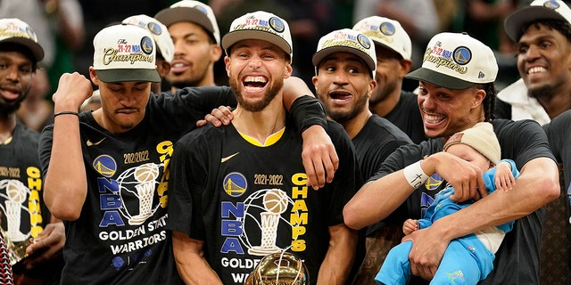 Golden State Warriors guard Stephen Curry (center) wins the Bill Russell Trophy after the Warriors defeat the Boston Celtics in Game 6 to win the NBA title in Boston on Thursday, June 16, 2022. Celebrate with your teammates who hold you as an MVP.