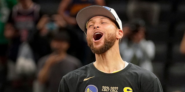 Golden State Warriors guard Stephen Curry celebrates with the Bill Russell Trophy for most valuable player after the Warriors defeated the Boston Celtics in Game 6 to win basketball's NBA Finals, Thursday, June 16, 2022, in Boston. 