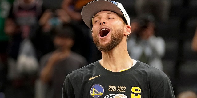 Golden State Warriors guard Stephen Curry celebrates with the Bill Russell Trophy for most valuable player after the Warriors defeated the Boston Celtics in Game 6 to win basketball's NBA Finals, Thursday, June 16, 2022, in Boston. 