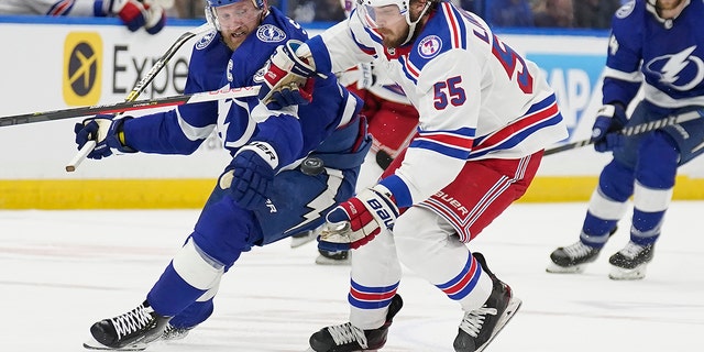 New York Rangers defenseman Ryan Lindgren (55) catches the puck in front of Tampa Bay Lightning center Steven Stamkos (91) during the second period in Game 3 of the NHL hockey Stanley Cup playoffs Eastern Conference finals Sunday, June 5, 2022, in Tampa, Fla.
