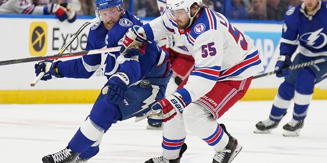 New York Rangers defenseman Ryan Lindgren (55) catches the puck in front of Tampa Bay Lightning center Steven Stamkos (91) during the second period in Game 3 of the NHL hockey Stanley Cup playoffs Eastern Conference finals Sunday, June 5, 2022, in Tampa, Fla.