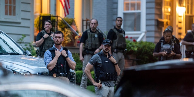 Law enforcement officers stand guard as protesters march past Supreme Court Justice Brett Kavanaugh's home on June 8, 2022, in Chevy Chase, Maryland.