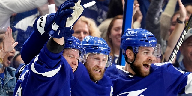 Tampa Bay Lightning center Steven Stamkos, center, celebrates his goal against the New York Rangers with Jan Rutta, right and Tampa Bay Lightning left wing Ondrej Palat, left, during the second period in Game 6 of the NHL hockey Stanley Cup playoffs Eastern Conference finals, Saturday, June 11, 2022, in Tampa, Fla. (AP Photo/Chris O'Meara)