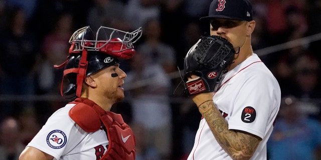 Red Sox pitcher Tanner Houck talks with catcher Christian Vazquez during the St. Louis Cardinals game at Fenway Park, Friday, June 17, 2022, in Boston.