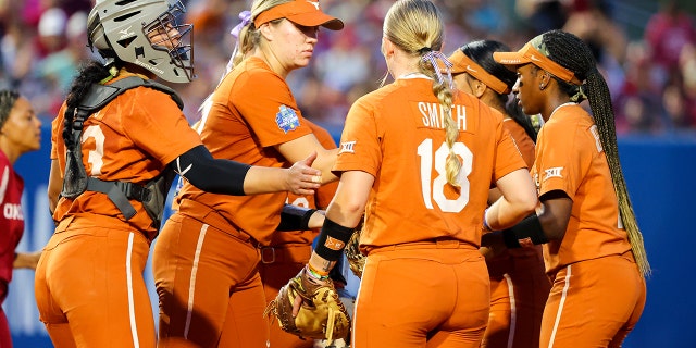 The Texas Longhorns meet at the pitching circle during the game against the Oklahoma Sooners during the Division I Women's Softball Championship held at ASA Hall of Fame Stadium on June 9, 2022 in Oklahoma City, Oklahoma.