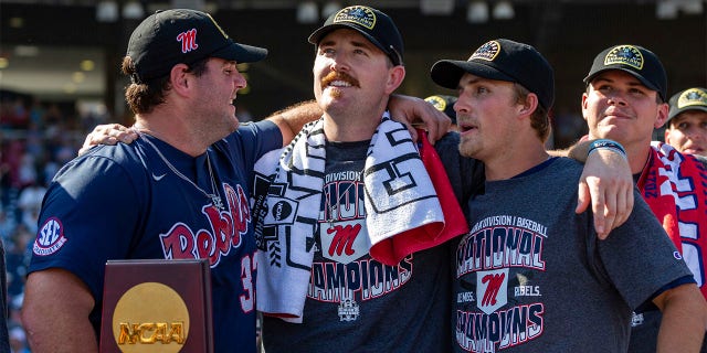 Mississippi's Ben Van Cleve (33), Tim Elko (25) and Justin Bench (8) look on during the closing video after a win over Oklahoma in Game 2 of the NCAA College World Series baseball finals, Sunday, June 26, 2022, in Omaha, Neb.