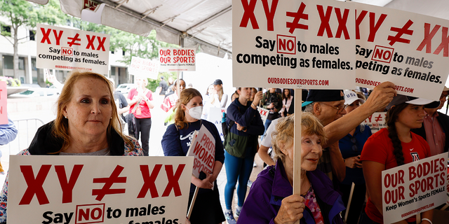 Demonstrators listen to the speaking program during an "Our Bodies, Our Sports" rally for the 50th anniversary of Title IX at Freedom Plaza on June 23, 2022 in Washington, DC. 