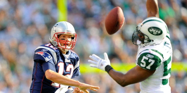 New England Patriots quarterback Tom Brady (12) is blocked by New York Jets linebacker Bart Scott (57) during the first half of a New England Patriots vs New York Jets game at New Meadowlands Stadium in East Rutherford, New Jersey.