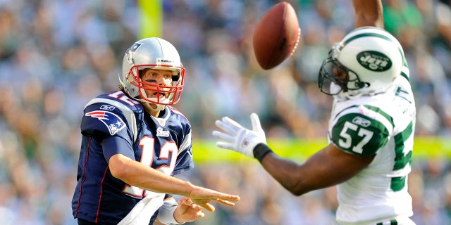 New England Patriots quarterback Tom Brady (12) gets a pass blocked by New York Jets linebacker Bart Scott (57) during the first half the New England Patriots vs New York Jets game at the New Meadowlands Stadium in East Rutherford, New Jersey.