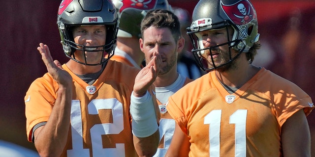 Tampa Bay Buccaneers quarterback Tom Brady (12) claps as he walks with Ryan Griffin (4) and Blaine Gabbert (11) during an NFL football minicamp Wednesday, June 8, 2022, in Tampa, Fla.