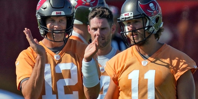 Tampa Bay Buccaneers quarterback Tom Brady (12) claps as he walks with Ryan Griffin (4) and Blaine Gabbert (11) during an NFL football minicamp Wednesday, June 8, 2022, in Tampa, Fla.