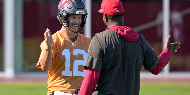 Tampa Bay Buccaneers quarterback Tom Brady, #12, greets offensive coordinator Byron Leftwich during an NFL football minicamp Wednesday, June 8, 2022, in Tampa, Fla.