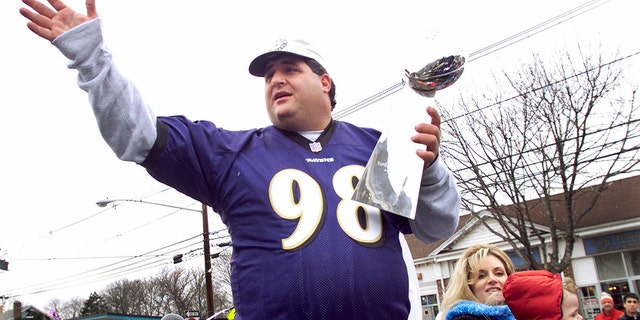 Tony Siragusa, defensive tackle for the Super Bowl champion Baltimore Ravens, holds the Vince Lombardi trophy as he rides with wife Kathy in a parade in his hometown of Kenilworth, N.J., March 4, 2001. 