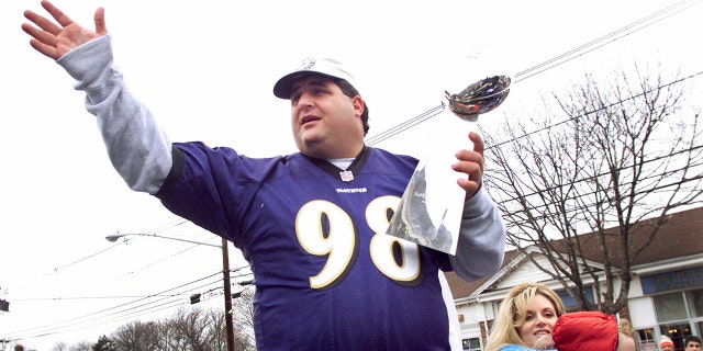 Tony Siragusa, defensive tackle for the Super Bowl champion Baltimore Ravens, holds the Vince Lombardi trophy as he rides with wife Kathy in a parade in his hometown of Kenilworth, N.J., March 4, 2001. 