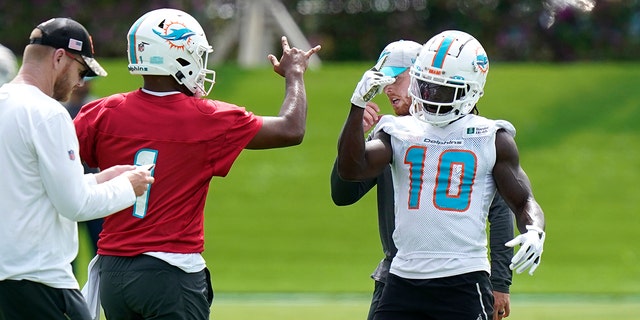 Miami Dolphins quarterback Tua Tagovailoa, #1, and wide receiver Tyreek Hill, #10, take part in drills at the NFL football team's practice facility, Thursday, June 2, 2022, in Miami Gardens, Fla.