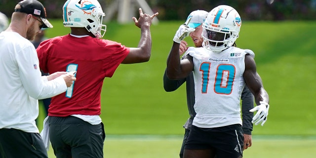 Miami Dolphins quarterback Tua Tagovailoa, #1, and wide receiver Tyreek Hill, #10, take part in drills at the NFL football team's practice facility, Thursday, June 2, 2022, in Miami Gardens, Fla.