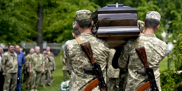 Ukrainian soldiers carry a casket with the remains of Army Captain Oleksander Makachek during a funeral in Zhytomyr, Ukraine, on Friday, June 3. 