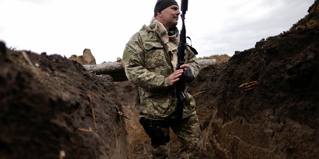 Vitalii, a Ukrainian Army officer, holds his weapon in a trench during tactical exercises at a military camp, amid Russia's invasion of Ukraine, in the Zaporizhzhia region, Ukraine April 30, 2022.  
