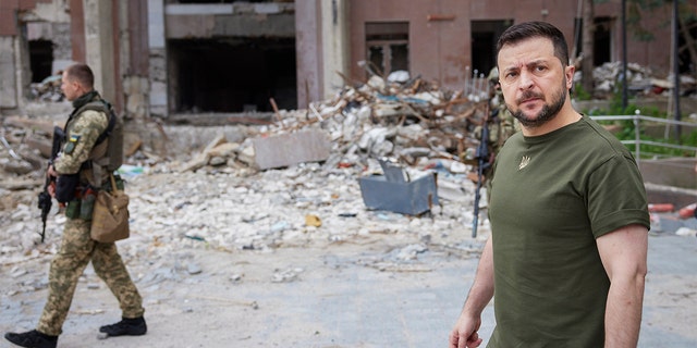 In this photo provided by the Ukrainian Presidential Press Office on Saturday, June 18, 2022, Ukrainian President Volodymyr Zelenskyy inspects damaged buildings as he visits the war-hit Mykolaiv region. 