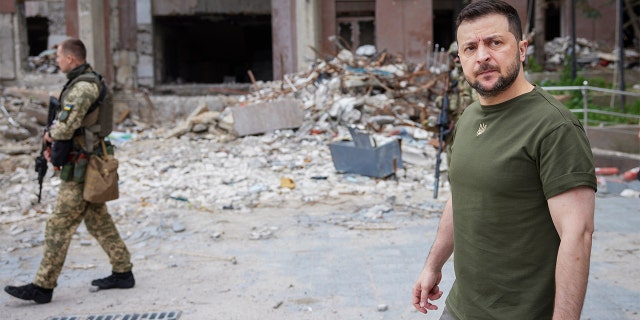 In this photo, provided by the Ukrainian Presidential Press on Saturday, June 18, 2022, Ukrainian President Volodymyr Zelensky inspects a damaged building during a visit to the war-stricken Mykolaiv region. .. 