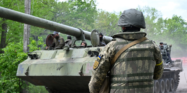 Український військовий дивиться на самохідну гаубицю на дорозі в Харківській області 17 травня.