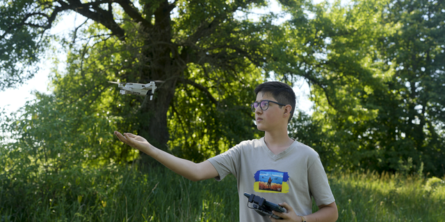 Andriy Pokrasa, 15, lands his drone on his hand during an interview with The Associated Press in Kyiv, Ukraine, on Saturday, June 11.