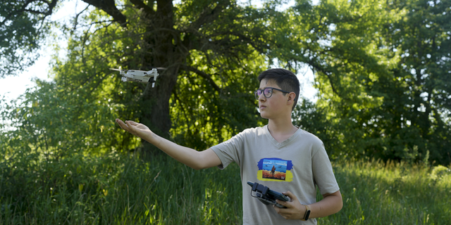 Andriy Pokrasa, 15, lands his drone on his hand during an interview with The Associated Press in Kyiv, Ukraine, on Saturday, June 11.