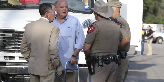 Uvalde Mayor Don McLaughlin, second from left, speaks with Texas Department of Public Safety troopers outside Robb Elementary School in Uvalde, Texas, on Wednesday, May 25.