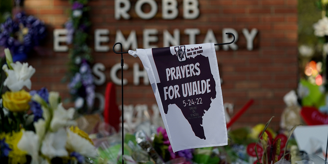 A banner hangs at a memorial outside Robb Elementary School on Friday, June 3.