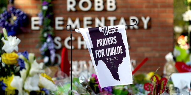 A banner hangs at a memorial outside Robb Elementary School, the site of a May mass shooting that killed 19 students and two teachers, on Friday, June 3.