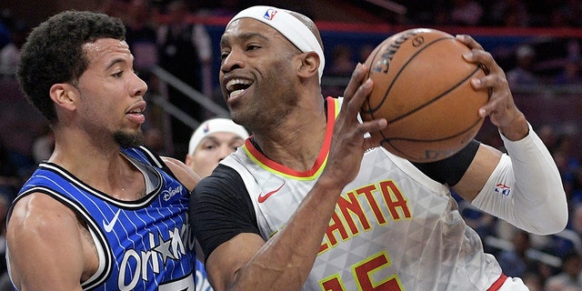 FILE - The Atlanta Hawks lead Vince Carter (15) into the basket during the first half of an NBA basketball game against Orlando Magic guard Michael Carter-Williams (7) in Orlando, Fla., Friday, April 5, 2019.