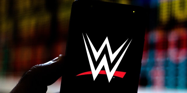 Neste infográfico, o logotipo da World Wrestling Entertainment (WWE) é exibido em um smartphone.