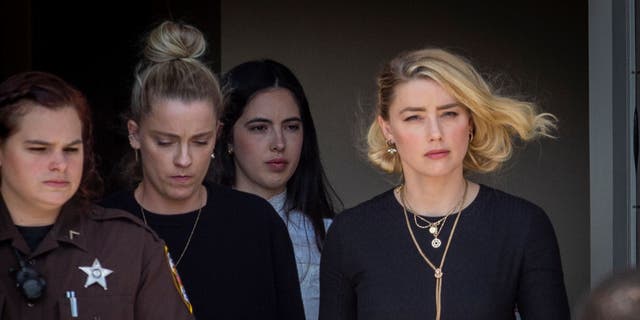 Actress Amber Heard, right, and her sister Whitney Heard, second left, depart the Fairfax County Courthouse on June 1, 2022 in Fairfax, Virginia after Johnny Depp won a $10.35 million judgment against her. 