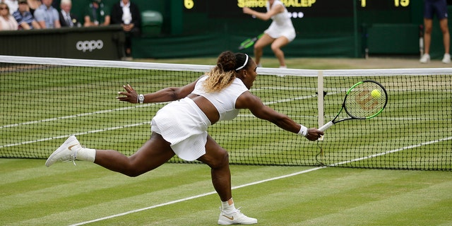 FILE - Serena Williams returns the ball to Romania's Simona Halep, background, during the women's singles final match on day twelve of the Wimbledon Tennis Championships in London, Saturday, July 13, 2019.