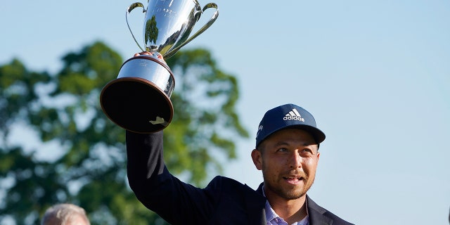 Xander Schauffele holds the trophy after winning the Travelers Championship golf tournament at TPC River Highlands, Sunday, June 26, 2022, in Cromwell, Conn.