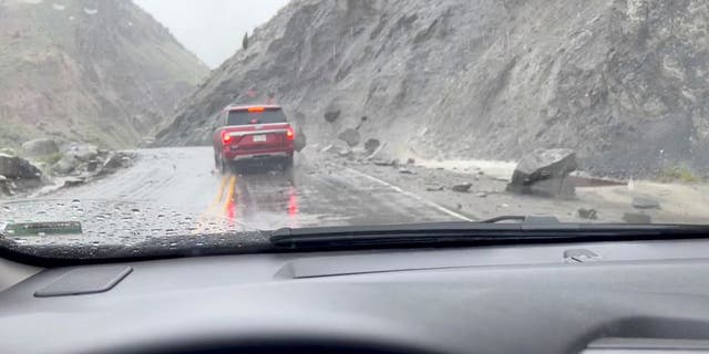 Photo of cars driving through canyon rockslide from 2022 Yellowstone flooding 