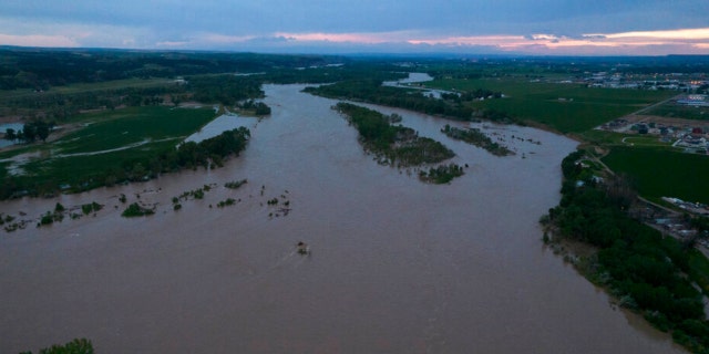 The roaring Yellowstone River is seen from the air sweeping over trees and near homes Tuesday, June 14, 2022, in Billings, Mont.
