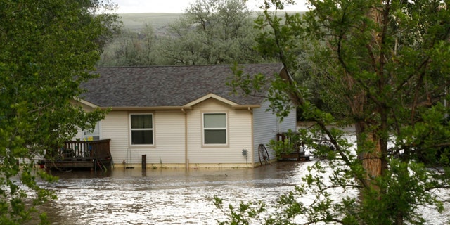 Floodwaters from the the Clarks Fork Yellowstone River surround a home near Bridger, Mont., on Monday, June 13, 2022. 