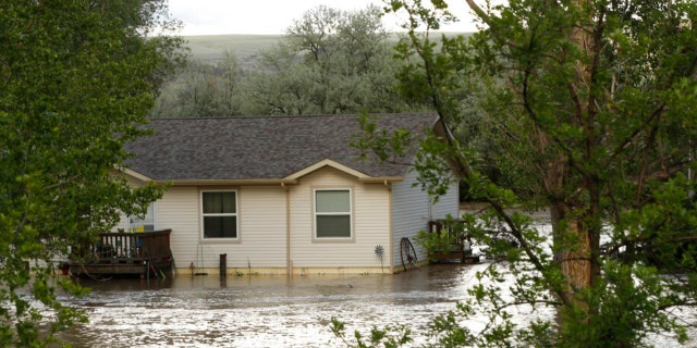 Floodwaters from the the Clarks Fork Yellowstone River surround a home near Bridger, Mont., on Monday, June 13, 2022. 