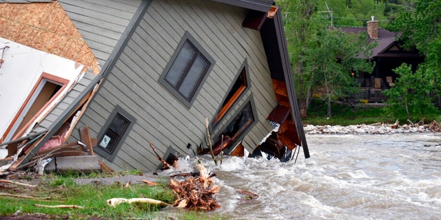 A house that was pulled into Rock Creek in Red Lodge, Mont., by raging floodwaters is seen Tuesday, June 14, 2022. Officials said more than 100 houses in the small city were flooded when torrential rains swelled waterways across the Yellowstone region. 