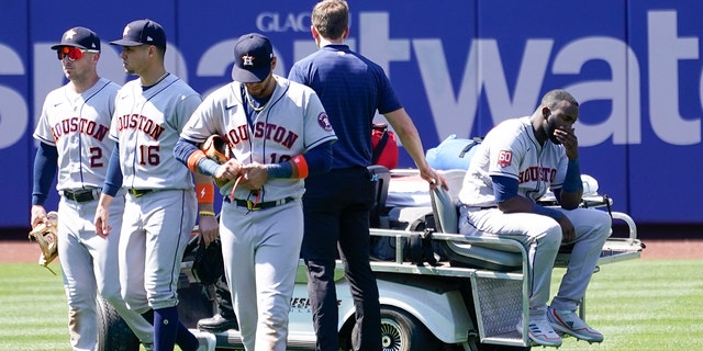 Houston Astros' Yordan Alvarez, right, is take off the field on a cart after he was injured colliding with Jeremy Pena trying to catch a fly ball by New York Mets' Dominic Smith during the eighth inning of a baseball game, Wednesday, June 29, 2022, in New York.