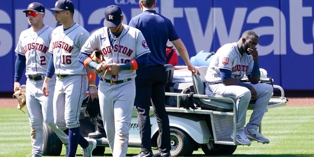 Houston Astros' Yordan Alvarez, right, is take off the field on a cart after he was injured colliding with Jeremy Pena trying to catch a fly ball by New York Mets' Dominic Smith during the eighth inning of a baseball game, Wednesday, June 29, 2022, in New York.