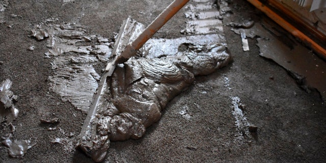 Mud scraped from the floor of a flooded home belonging to Lindi O'Brien is seen, June 17, 2022, in Fromberg, Montana.