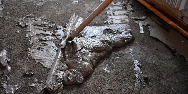 Mud scraped from the floor of a flooded house belonging to Lindi O'Brien is seen, June 17, 2022, in Fromberg, Montana.