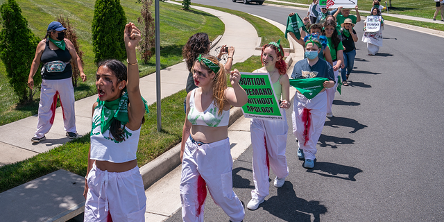 Abortion-rights activists with Rise Up 4 Abortion Rights chant after marching to the home of Supreme Court Justice Amy Coney Barrett on June 18, 2022, in Falls Church, Virginia.