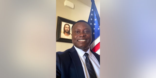 Alma Ohene-Opare posing with an American Flag on the day he became a U.S. citizen.
