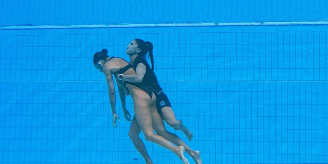 المدربة أندريا فوينتيس (على اليمين) تنقذ الأمريكية أنيتا ألفاريز (يسار) من قاع المسبح لإنقاذها بعد أن أغمي عليها في بطولة العالم للرياضات المائية في بودابست 2022 في بودابست في 22 يونيو 2022.