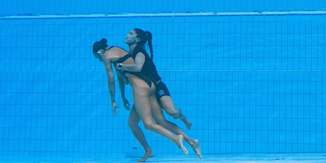 Coach Andrea Fuentes (R) saves Anita Alvarez (L) of the US from the bottom of the pool to save her after being passed out at the Budapest 2022 World Aquatics Championships on June 22, 2022 in Budapest.