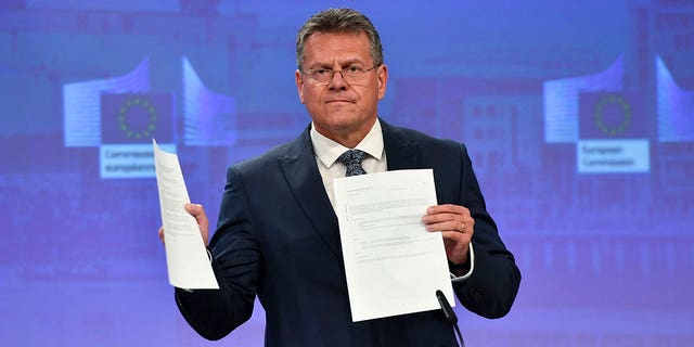 European Commissioner for Inter-institutional Relations and Foresight Maros Sefcovic holds up documents as he speaks during a media conference at EU headquarters in Brussels, Wednesday, June 15, 2022. Britain's government on Monday proposed new legislation that would unilaterally rewrite post-Brexit trade rules for Northern Ireland, despite opposition from some U.K. lawmakers and EU officials who say the move violates international law. (AP Photo/Geert Vanden Wijngaert)